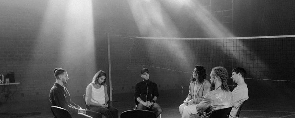 Group of diverse people sitting in a circle sharing tea.